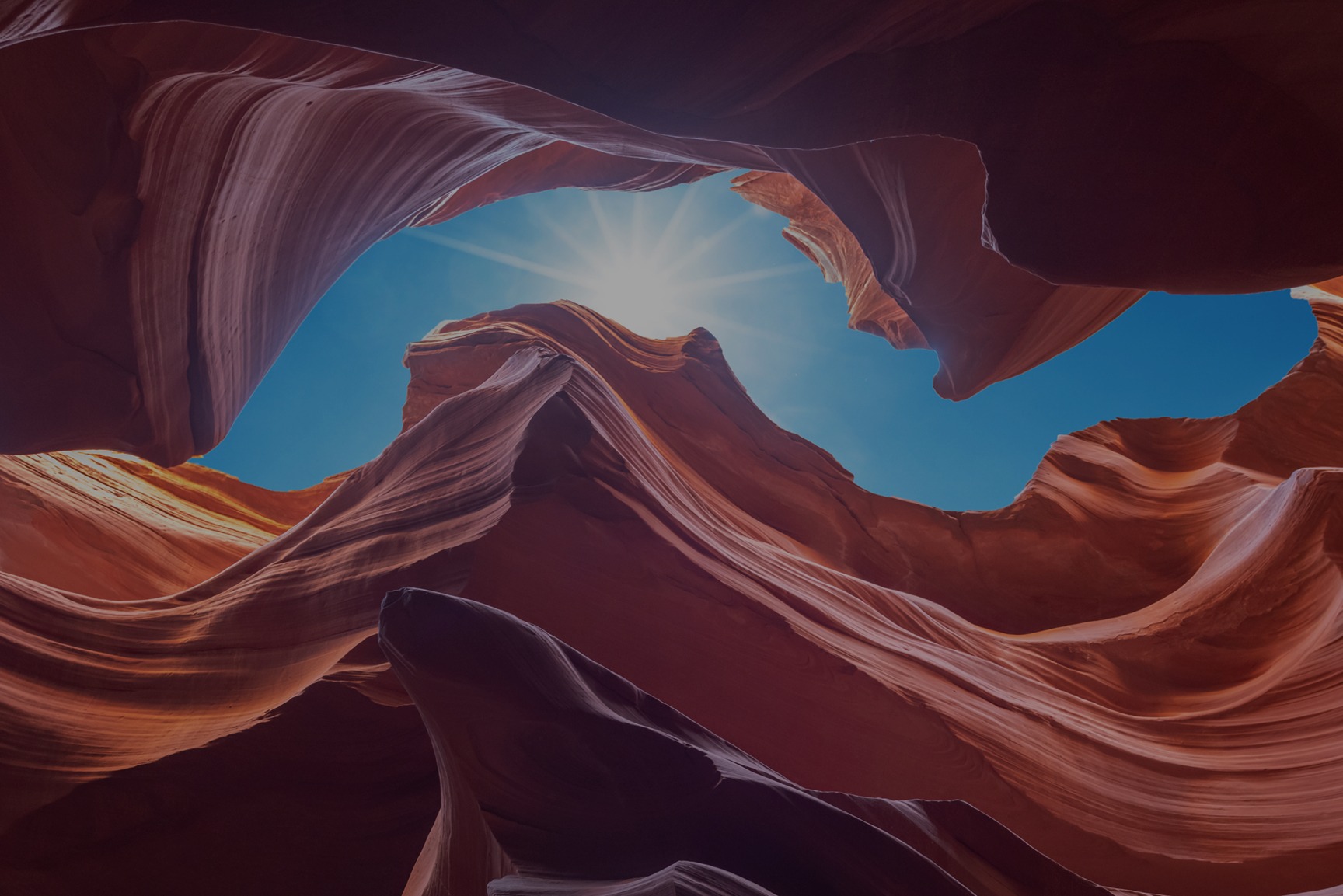 Smooth sandstone walls of a desert slot canyon with light streaming in from above